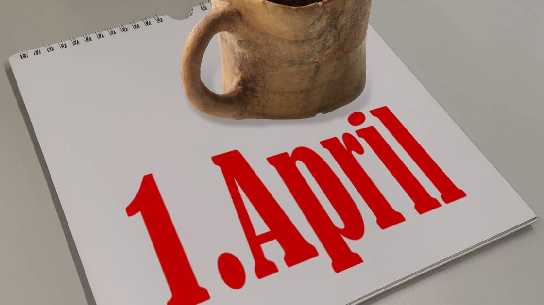 Eine Tasse aus Holz steht auf einem Kalender, der den 1. April anzeigt. | © Schweizerisches Nationalmuseum